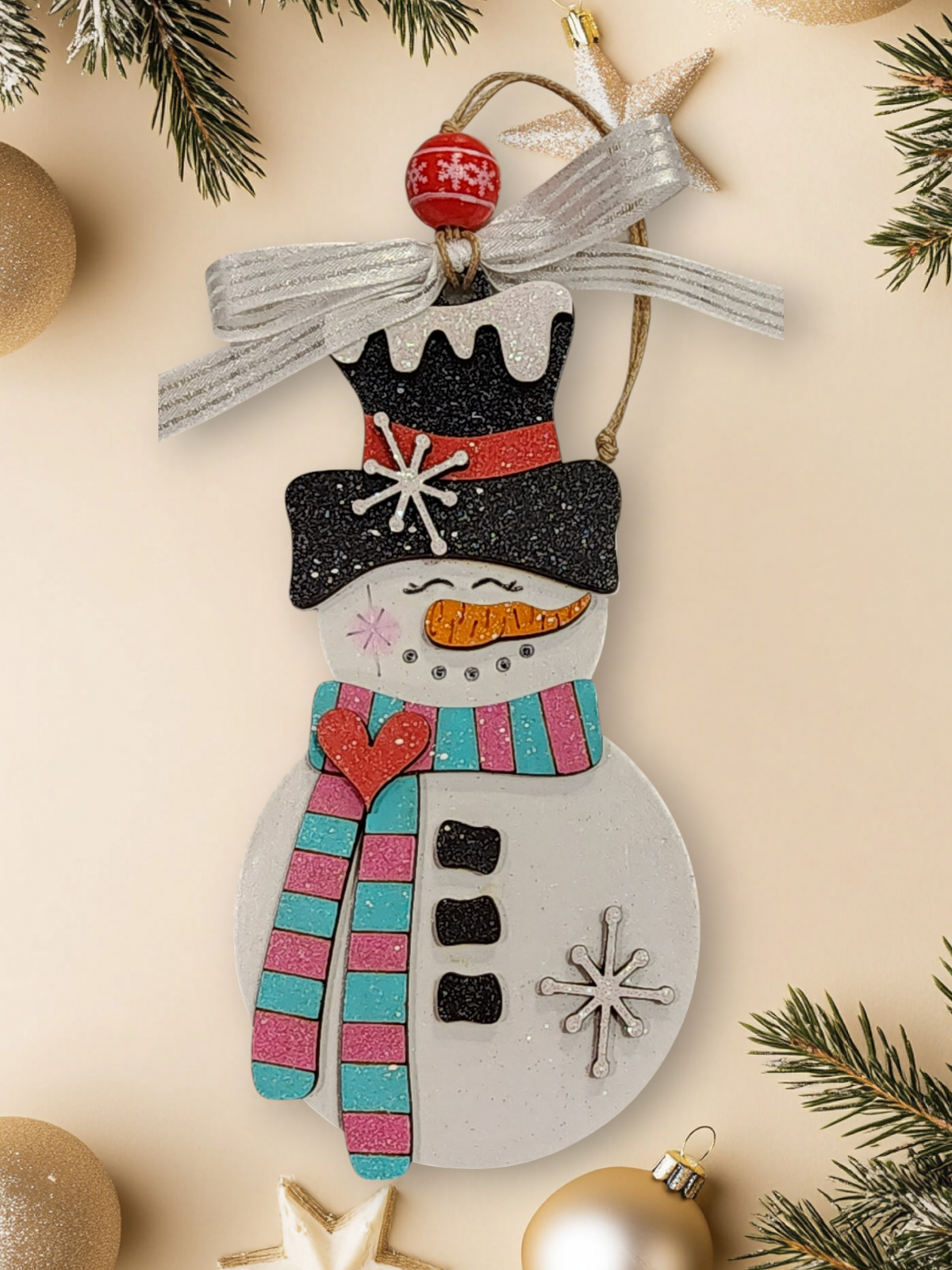 Whimsical layered wood snowman ornament with teal and pink striped scarf