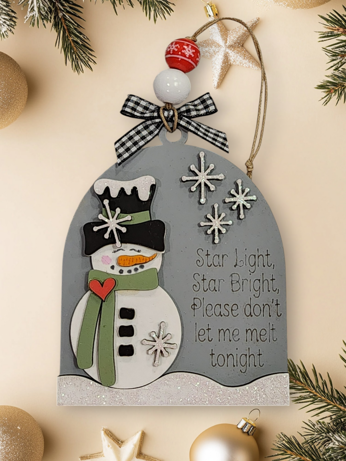 Decorative Christmas ornament with a snowman design and festive text on a gray background.